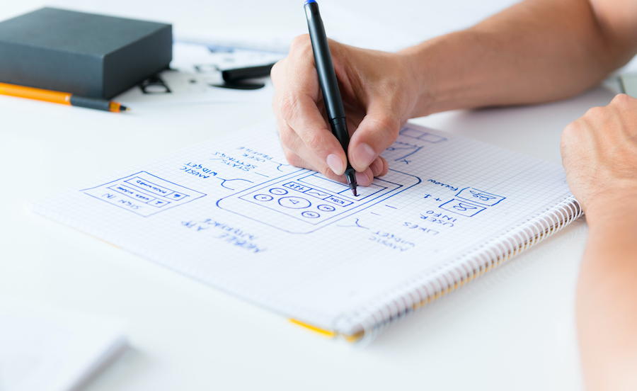 Designer develop a mobile application usability and drawing its framework on a paper.